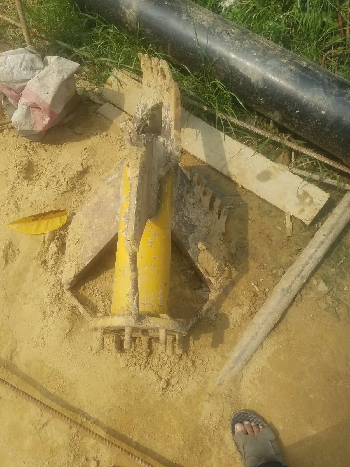 Tripod-mounted hydraulic drilling rig between buildings
