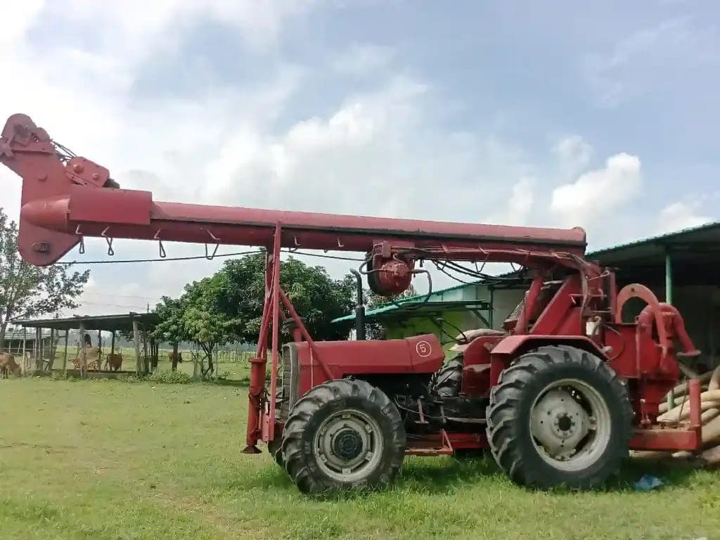 Tractor-mounted drilling rig in open field